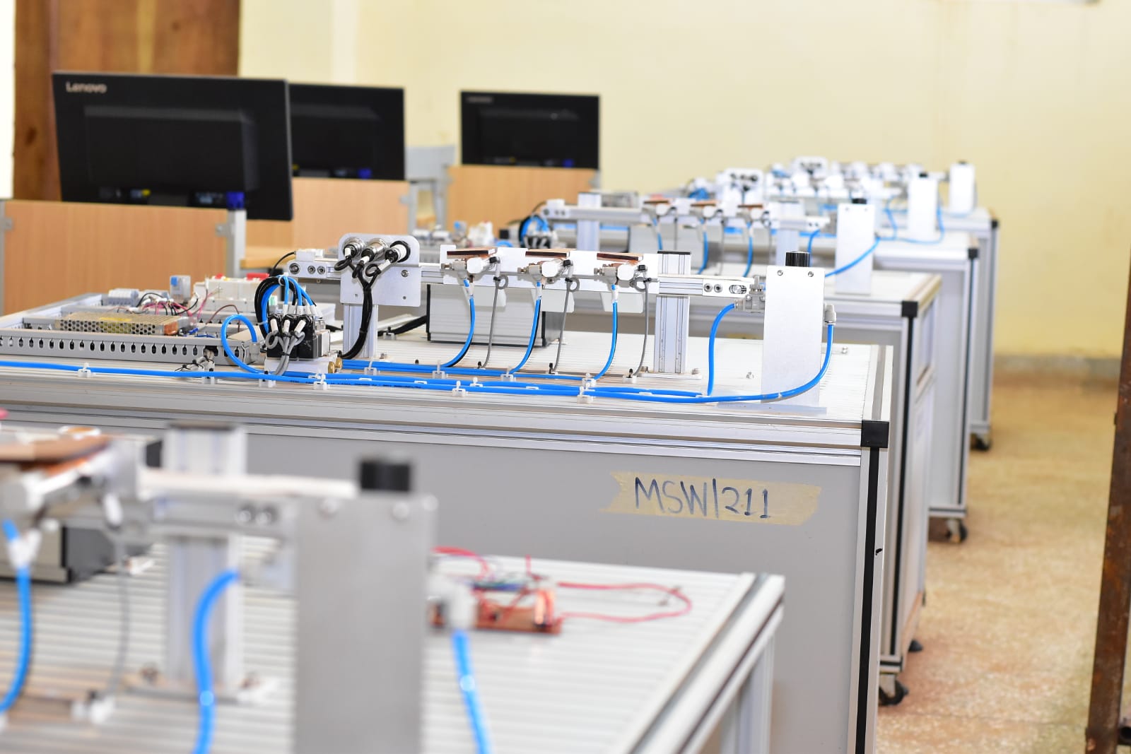 Students wiring an electrical control panel in a modern lab